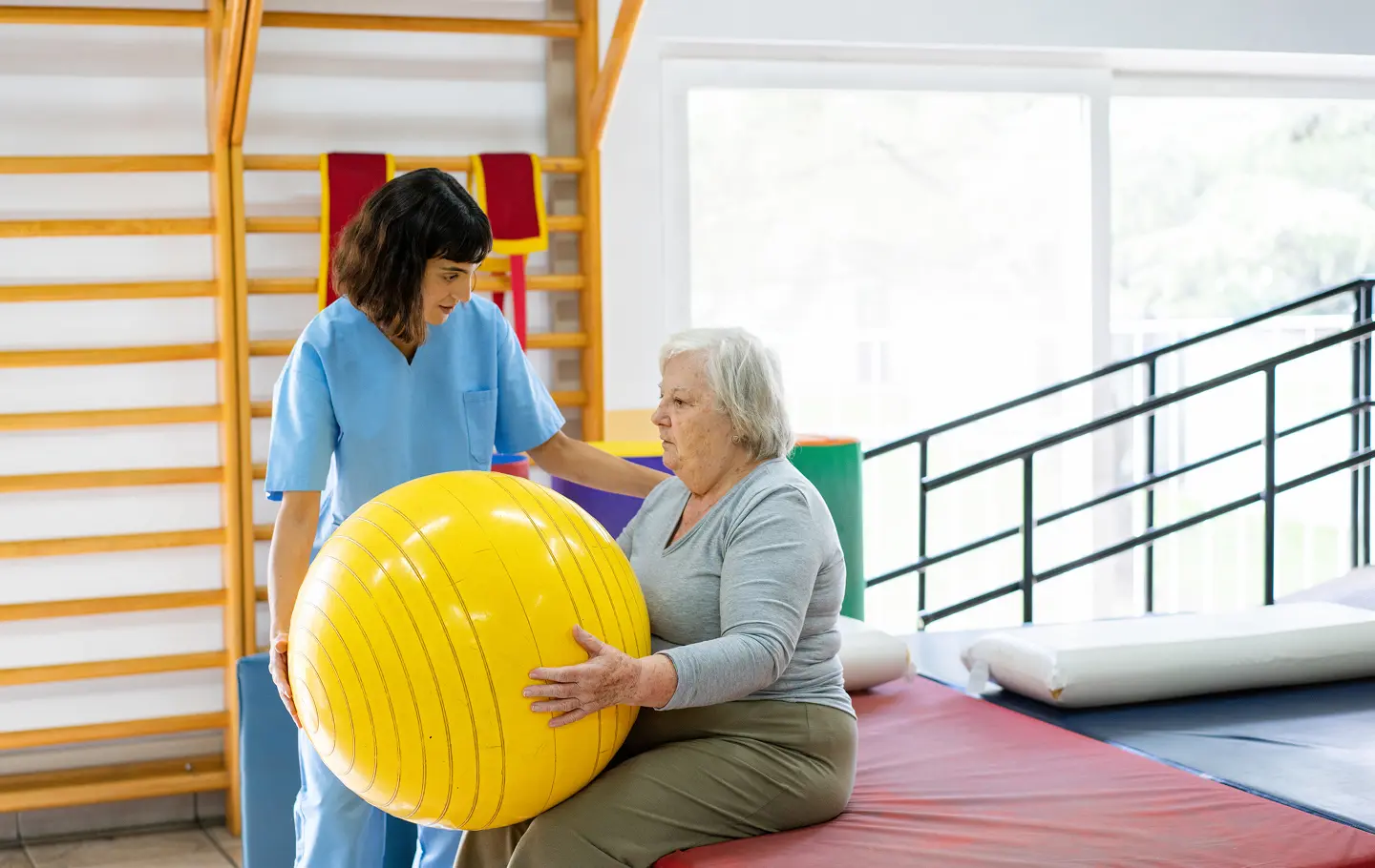 Therapist assisting elderly patient with exercise